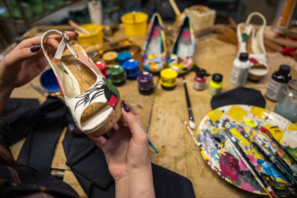istock Creative female shoemaker painting the high heels 1398461466