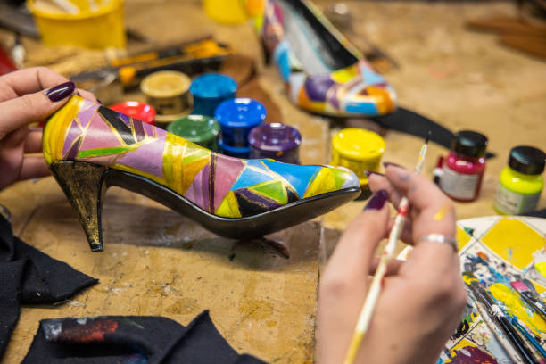 istock Creative female shoemaker painting the high heels 1398461487