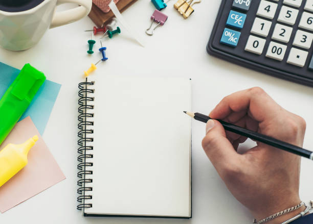 istock Woman writing in notebook with pen at desk. Mock up 1398464398