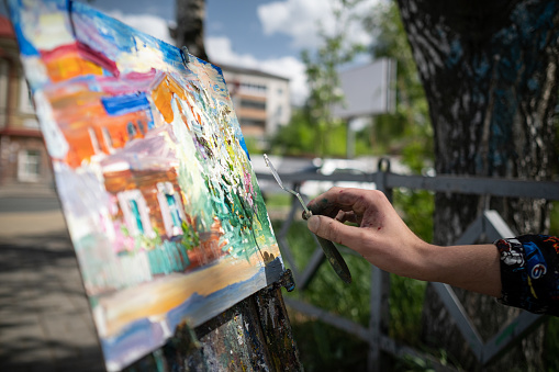 20th of May 2022, Russia, Tomsk, The street painter drawing building outside