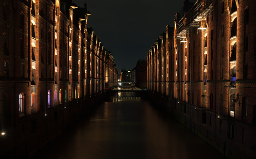 Hamburg, Germany. Speicherstadt perspective view at night. The largest warehouse district in the world where the buildings stand on timber-pile foundations of oak logs