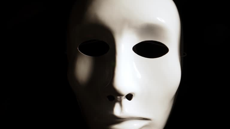 White face mask on dark background.