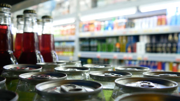Close-up of many colorful cans and bottles of soda on store shelves stock photo