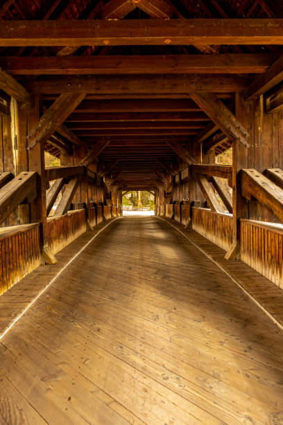 Tourists walking on the Covered Bridge,  Guelph, Canada. Pedestrian & cyclist bridge built in 1992 & inspired by the lattice-covered bridges of the 1880s.
