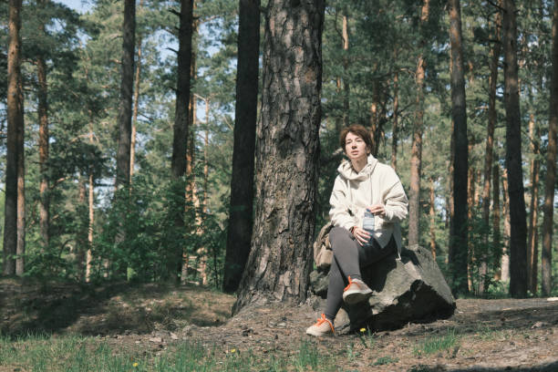 istock Woman is taking a break from exercising in forest 1398482540