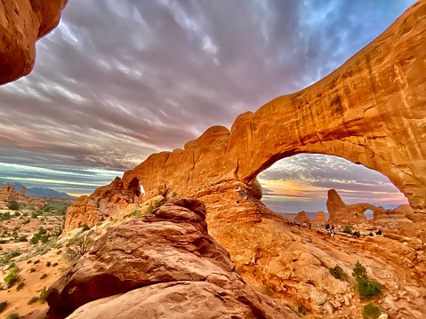 Sunset at a natural arch in Arches National Park, Utah, USA.