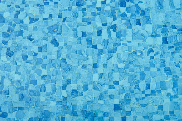 vista superior da cáustica superficial rasgou água na piscina e flui com ondas de fundo. parede de mosaico na cor azul para copiar espaço de fundo abstrato. - from the bottom - fotografias e filmes do acervo