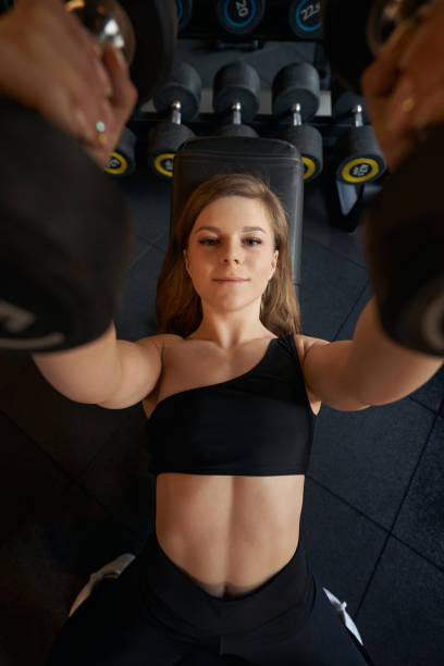 istock Sportswoman performing dumbbell bench press during resistance training 1398486184