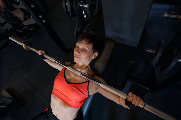 istock Focused female bodybuilder performing incline bench press 1398486349