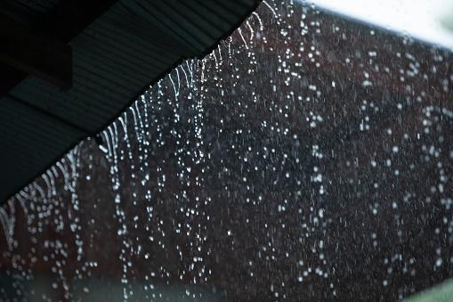 Close-up shot of rain drops on the side window of the car