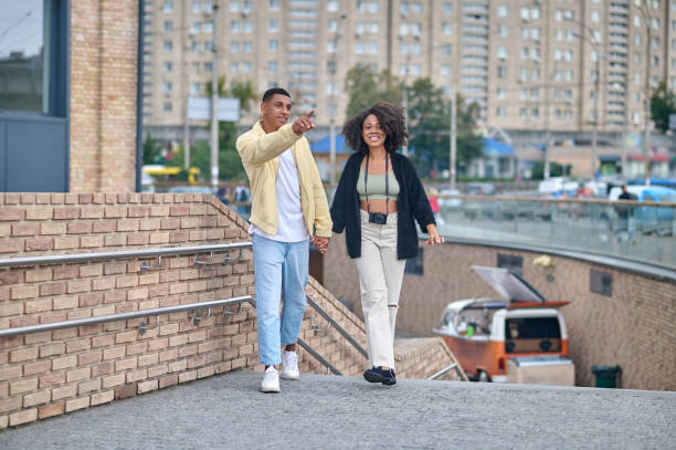 istock Guy pointing hand to side walking with girl 1398489144