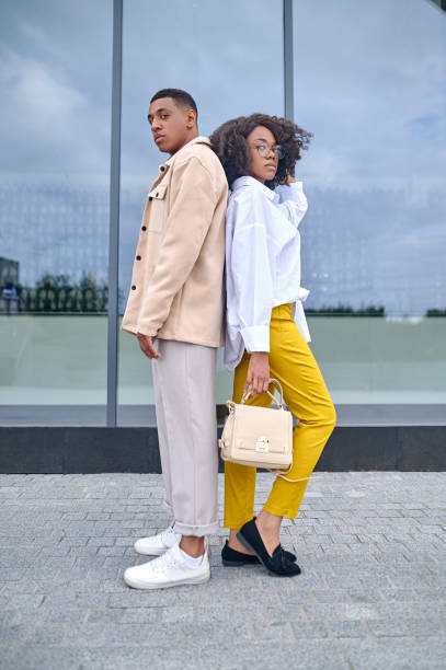 istock Guy and girl standing back to back 1398489201