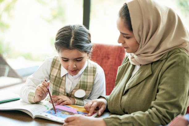 saudyjska matka i córka pracujące nad zadaniami szkolnymi - workbook education school uniform child zdjęcia i obrazy z banku zdjęć