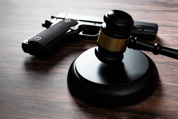 Gun and gavel on the table stock photo