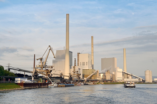 Mannheim, Germany - April 2022: Large power station on the River Rhine at dusk. The plant is operated by CKM.