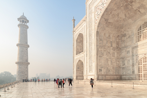 Agra, India - 8 November, 2018: Visitors walking along the Taj Mahal complex. The Taj Mahal is a popular tourist attraction of South Asia.