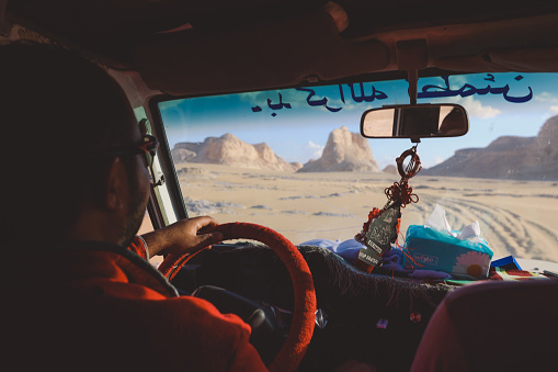 Farafra, Egypt - November 05, 2021: Local Egyptian Man Driver in the White Desert Protected Area on the Adventure 4x4 car