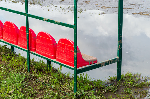 a muddy bench by a huge puddle