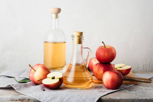 vinagre de sidra de manzana y manzanas. - vinagre fotografías e imágenes de stock