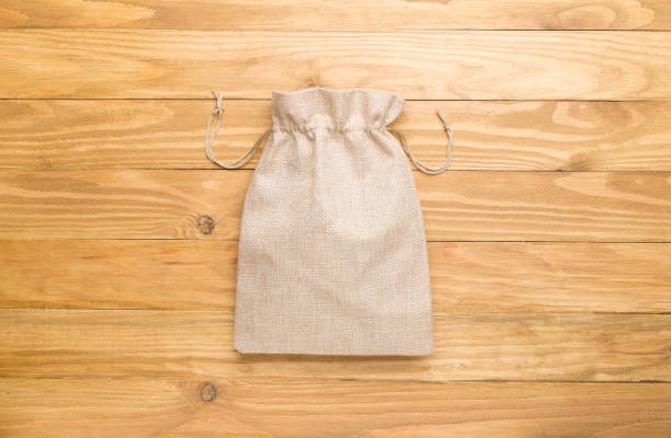 istock Burlap eco sack on wooden background, top view 1398496041