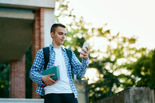 istock University student using phone in front of university 1398499101