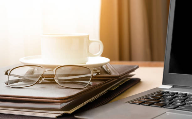 istock Working from home with laptop glasses document file and coffee cup hot in the morning. Workspace background composition with space for text. Enjoy relax time during working at home with copy space. 1398500515