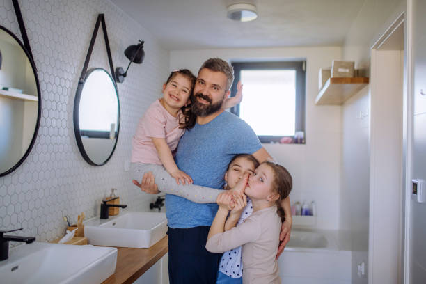 istock Father bonding with his three little daughters in bathroom and looking at camera. 1398501182
