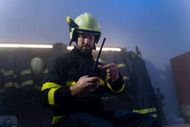 istock Mature firefighter preparing for action in fire station at night. 1398503587