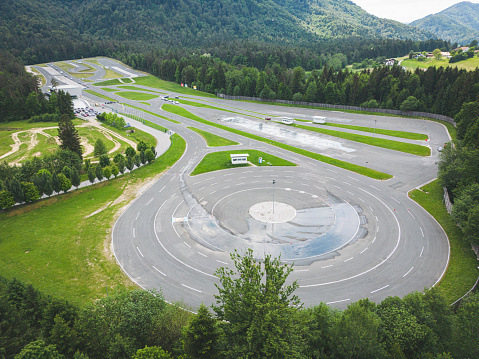 Aerial view, drone shoot, drone flying over safe driving center in the countryside. Car range was created for practicing safety driving in dangerous conditions, such as snow, rain… The main thing is to learn safety driving. This is a built facility for carrying out safety driving exercises. It is also appropriate for testing vehicles and how they perform in different weather conditions, such as snow, ice rain, slippery road. All the exercises are done in a safe environment.