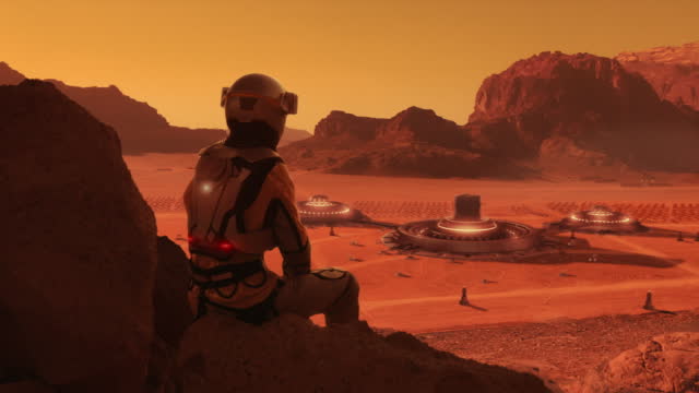 Astronaut on planet Mars watching a space station. Human colony in space