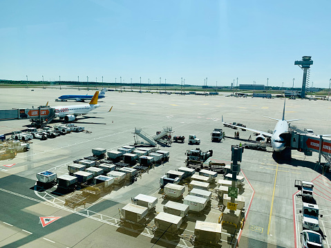 Berlin, Germany - May 05, 2022: Boarding flights with containers around the Berlin Brandenburg international airport