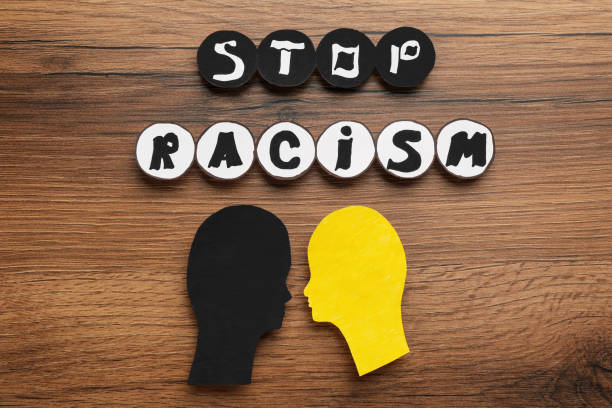 istock Phrase Stop Racism and different head cutouts on wooden table, flat lay 1398514268