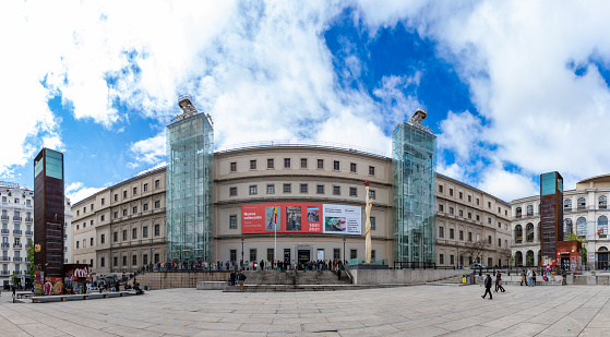 Madrid, Spain - April 23, 2022: A panorama picture of the Museo Nacional Centro de Arte Reina Sofía's main facade with visitors queuing up.