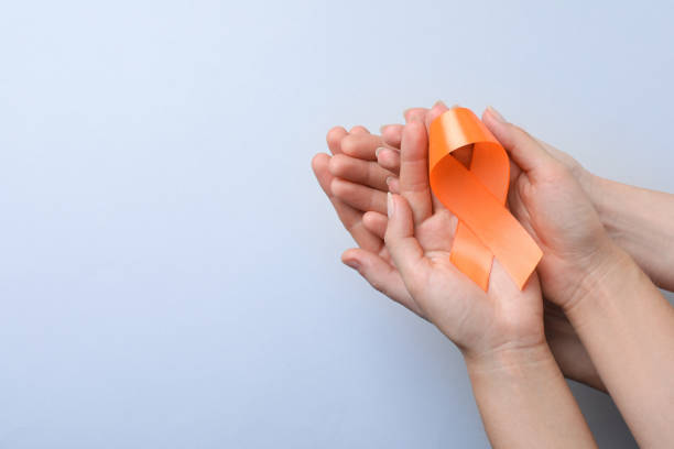 istock Couple holding orange ribbon on light grey background, top view with space for text. Multiple sclerosis awareness 1398514546