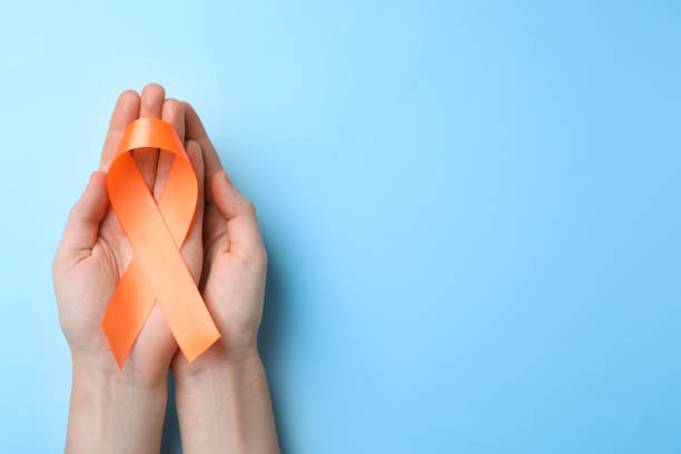 man holding orange ribbon on light blue background, top view with space for text. multiple sclerosis awareness - esclerose múltipla imagens e fotografias de stock