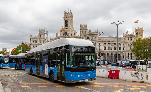 Madrid, Spain - April 23, 2022: A picture of a Madrid bus in front of the Cibeles Palace.