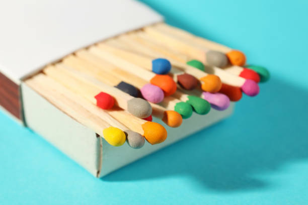 Matches with colorful heads in box on light blue background, closeup