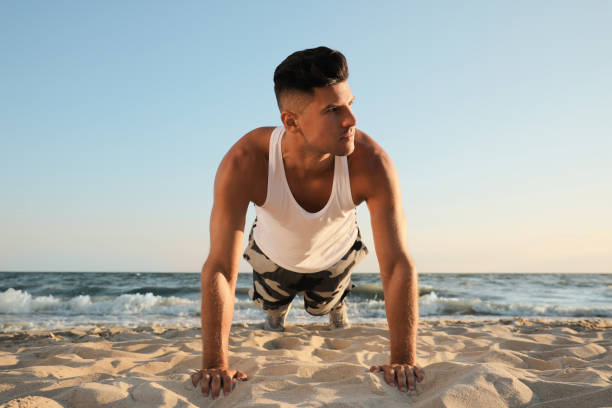 istock Sporty man doing plank on sandy beach 1398515904