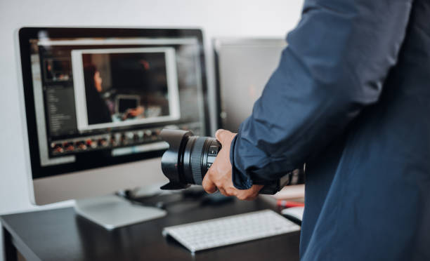 istock photographer hand camera and computer on desk 1398520474