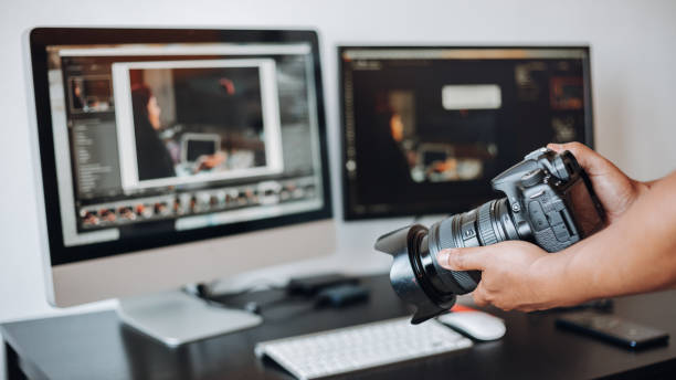istock photographer hand camera and computer on desk 1398520480