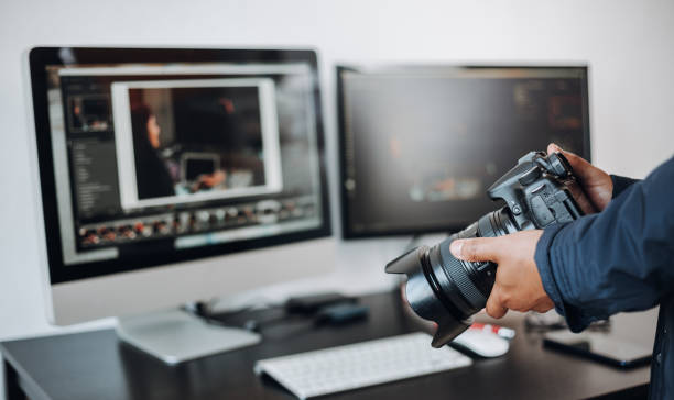 istock photographer hand camera and computer on desk 1398520485