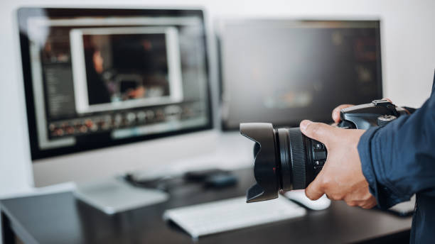 istock photographer hand camera and computer on desk 1398520487