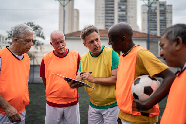 istock Coach discussing play strategy with the team on the soccer field 1398520747