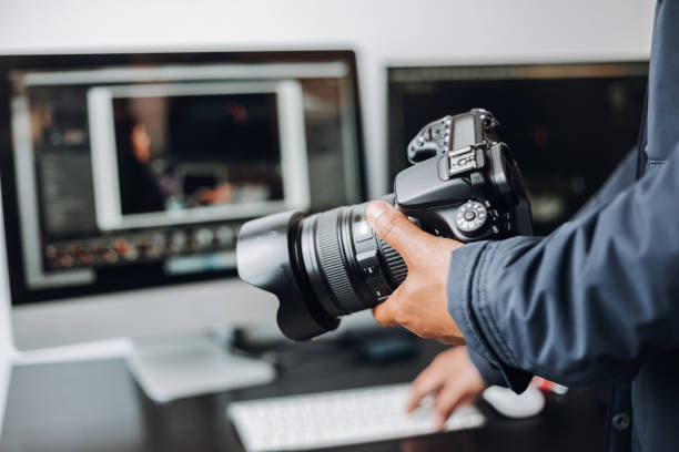 istock photographer hand camera and computer on desk 1398520773