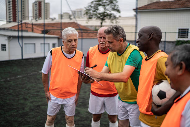 istock Coach discussing play strategy with the team on the soccer field 1398520810