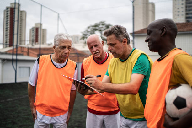 istock Coach discussing play strategy with the team on the soccer field 1398520816