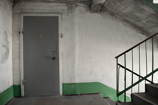 old dirty soviet entrance in an apartment building after a fire, a corridor in the entrance, a staircase