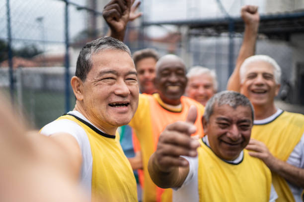 hommes âgés prenant des selfies sur le terrain de football - point de vue de la caméra - soccer player soccer men smiling photos et images de collection