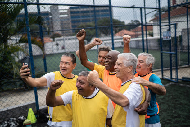 istock Senior men taking selfies or filming using mobile phone on the soccer field 1398521717