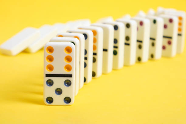 istock Domino knuckles on a yellow background, domino effect. 1398523051